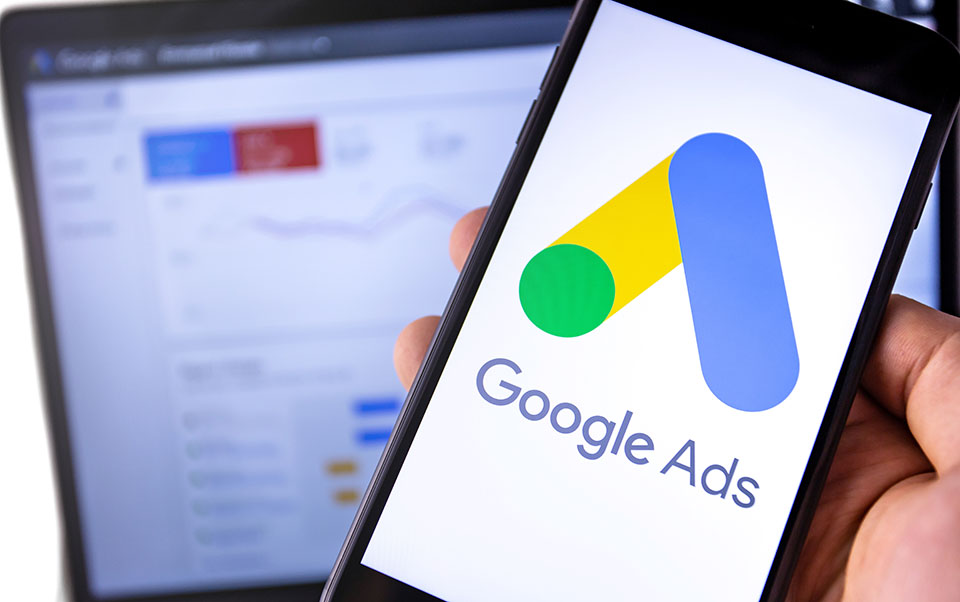 smartphone with Google Ads on the screen and display notebook ba